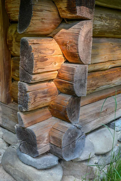 The corner of a house made of wooden logs, the corner joint of a chopped log house.Rustic log cabin wood building structure homestead historic site texture background .