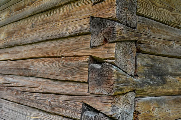 The corner of a house made of wooden logs, the corner joint of a chopped log house.Rustic log cabin wood building structure homestead historic site texture background .