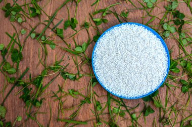 Arka plan olarak amonyum nitrat peletleri, üst görünüm. Maden gübresi. Doğal bir kimyasal madde ya da endüstriyel kimyanın ürünü olabilir..