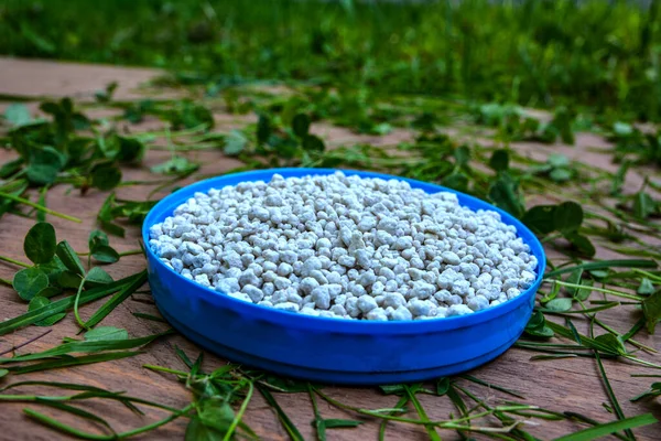 Close up of mineral fertilizer granules.chemical granulated fertilizer closeup.complex fertiliser granules on dark soil background.