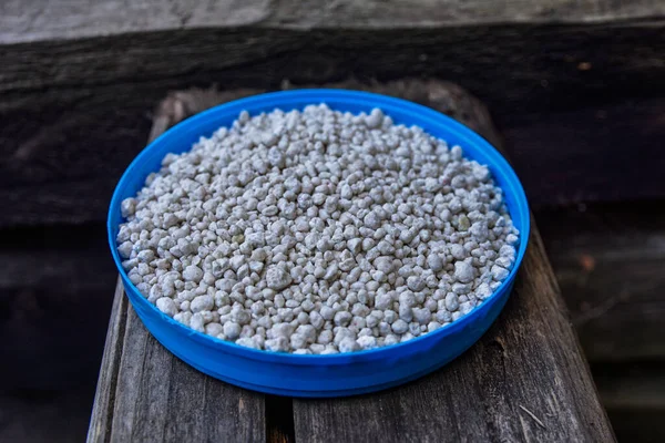 Close up of mineral fertilizer granules.chemical granulated fertilizer closeup.complex fertiliser granules on dark soil background.