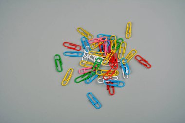 The colorful paperclips. Bright colored paper clips on a gray Desk. concept school. Copy space