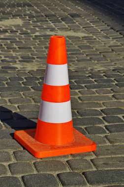 Orange traffic cone for road works isolated on white background .bright orange traffic cones standing in a row on dark asphalt