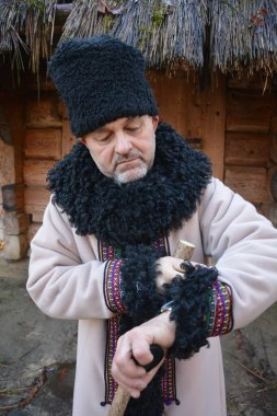 Dakiklik ve insan konsepti - Kol saatini kontrol eden kıdemli bir adam ya da şehirde elinde akıllı bir saat. Karalama şapkalı ve koyun derisi ceketli yaşlı bir adam saatine bakar..