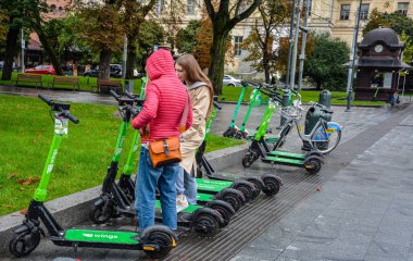Lviv. Ukrayna. Şehrin sokaklarında Temmuz 2021 'de kiralık elektrikli scooter' lar. Şehirde her gün elektrikli scooter ekonomik araç kullanılıyor. Limon kiralama mobiletlerinin sokak manzarası bir iş yerinin önünde sıralanmıştı.