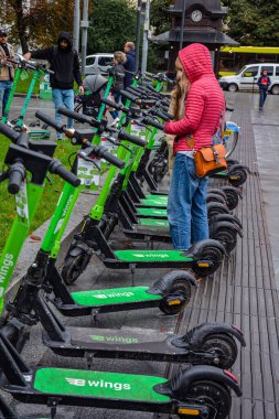 Lviv. Ukrayna. Şehrin sokaklarında Temmuz 2021 'de kiralık elektrikli scooter' lar. Şehirde her gün elektrikli scooter ekonomik araç kullanılıyor. Limon kiralama mobiletlerinin sokak manzarası bir iş yerinin önünde sıralanmıştı.