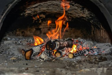 Evin şöminesinde yanan ahşap odunları kaplayan alevlerin yakın plan görüntüsü. .