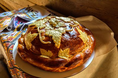 Beyaz havluyla geleneksel geleneksel düğün ekmeği. Masanın üzerinde işlenmiş havlunun yanında duran tuzlu taze Ukrayna somunu..