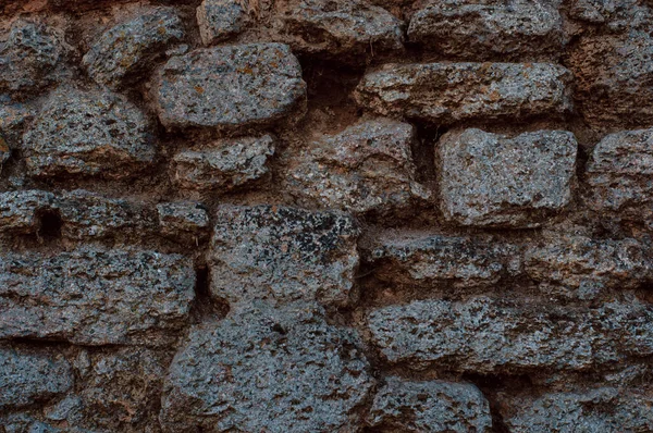 The texture of the stone wall. Background texture of the stone wall of the old castle. Stone wall as background or texture. Part of a stone wall, for background or texture