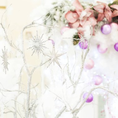 Bu fotoğraf Noel süslemelerini tasvir ediyor. Parlayan ampuller. Tatil için süslenmiş Noel baloları. Çok renkli aksesuarlar. Noel ağacının dalları çelenklerle süslenmiştir..