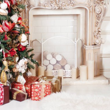 Bu fotoğraf, odadaki köknar ağacının yanında yerde duran güzel Noel hediye kutularını gösteriyor.