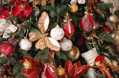 Bu fotoğraf Noel süslemelerini tasvir ediyor. Parlayan ampuller. Tatil için süslenmiş Noel baloları. Çok renkli aksesuarlar. Noel ağacının dalları çelenklerle süslenmiştir..