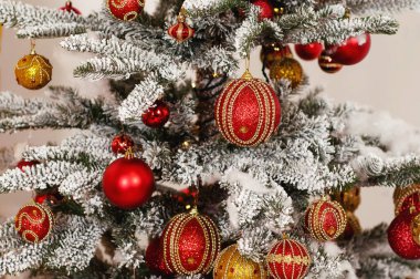 Bu fotoğraf Noel süslemelerini tasvir ediyor. Parlayan ampuller. Tatil için süslenmiş Noel baloları. Çok renkli aksesuarlar. Noel ağacının dalları çelenklerle süslenmiştir..