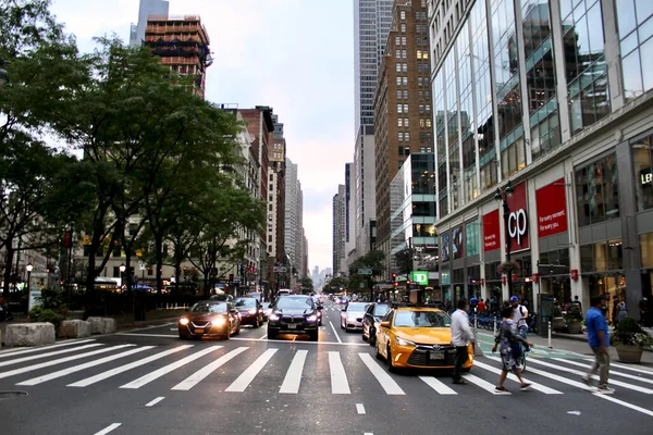 Manhattan, New York, ABD - 10 Ekim 2020: Sarı renkli bir taksi tarafından neredeyse çarpılan bir adamın bulanık görüntüsü. Bir yaya geçidinde trafik sinyali kavşağında hareket halindeki bir yayanın yavaş çekim hızı...