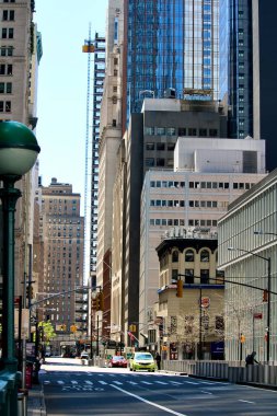 Manhattan, New York City, ABD - 10 Mayıs 2020: Covid 19 salgını sırasında her iki tarafında yüksek binalar olan bir cadde.