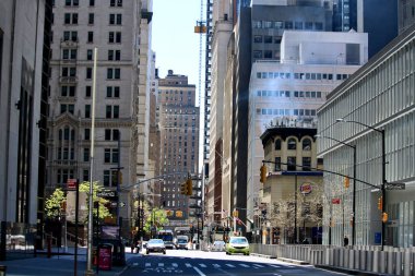 Manhattan, New York City, ABD - 10 Mayıs 2020: Covid 19 salgını sırasında her iki tarafında yüksek binalar olan bir cadde.