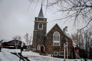 Placid Gölü Şehri, New York, ABD - 28 Kasım 2019: Adirondack Toplum Kilisesi, karlı bir kış gününde antik bir kilise.