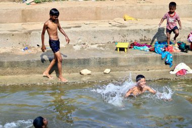 Davangere, Karnataka, Hindistan - 17 Aralık 2021: Yerel bir su kanalında yüzen genç Hintli bir çocuğun güzel bir portresi.