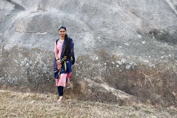 インドのカルナータカ州チトラドゥルガ砦の石の遺跡の前にポーズをとる伝統的な若いインド人女性 ストック写真
