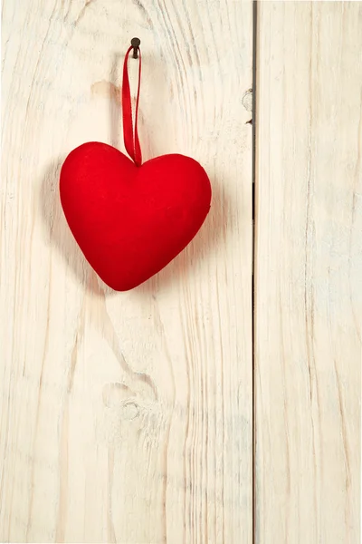 San Valentín. corazón de tela roja colgado en la pared de madera Imágenes de stock libres de derechos