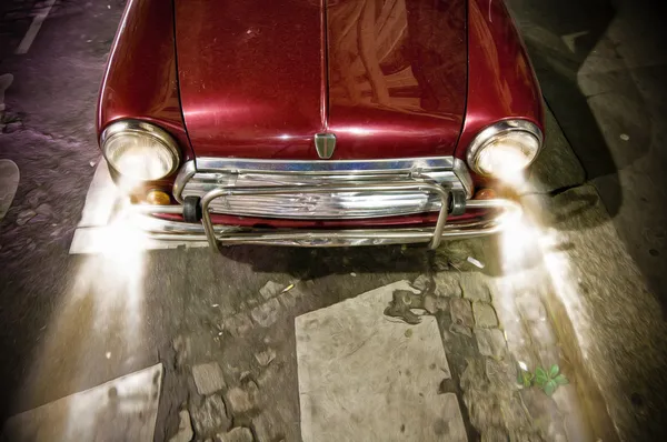 Red vintage car on road with working headlights. — Stock Photo, Image