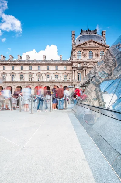 Visitantes em fila na pirâmide do Louvre . Imagens De Bancos De Imagens