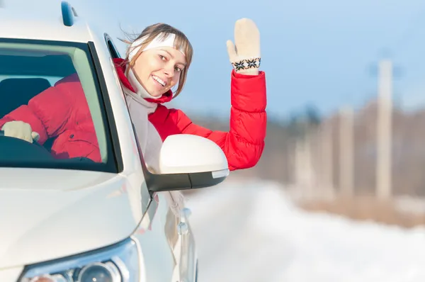 Gelukkig mooie vrouw reist met de auto in de winter. — Stockfoto