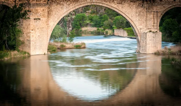 Most se odráží v řece toledo, Španělsko, Evropa. — Stock fotografie