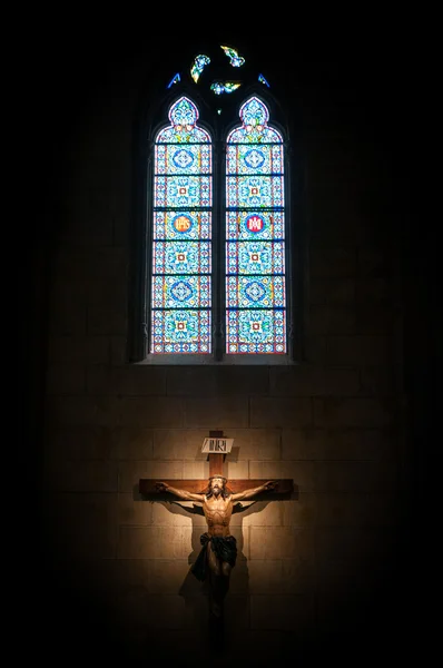 Kruzifix in Kirche unter Buntglasfenster. — Stockfoto