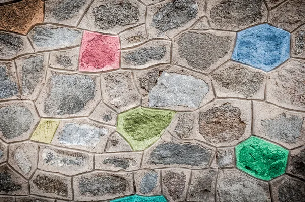 Pared de piedra gris con bloques de colores brillantes . — Foto de Stock