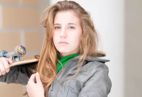 Porträt eines hübschen Mädchens mit Skateboard im Freien. — Stockfoto