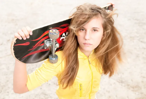 Porträt eines hübschen Mädchens mit Skateboard im Freien. — Stockfoto