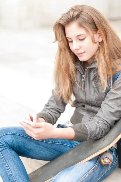 Porträtt av söt flicka med skateboard utomhus. — Stockfoto