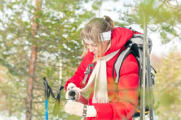 Nő visel piros sport kabát téli erdőben. — Stock Fotó