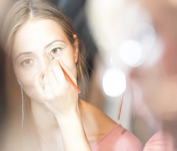 Jonge mooie vrouw krijgen make-up met borstel. — Stockfoto