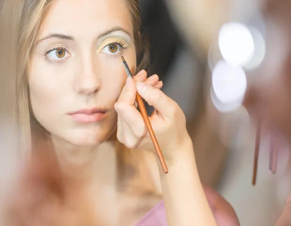 Young pretty woman getting make-up with brush. — Stock Photo, Image