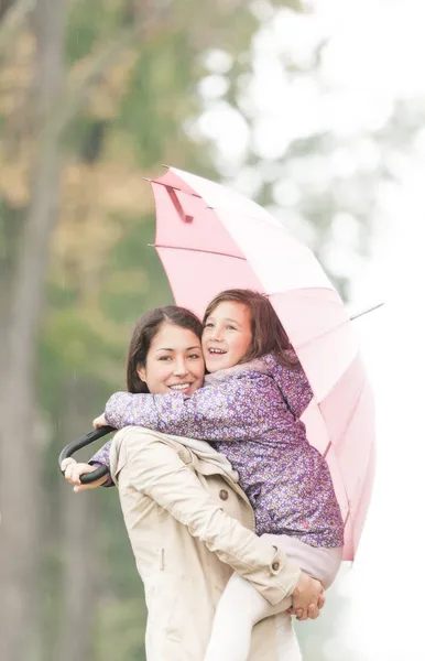 母と娘秋の傘の下で. — ストック写真