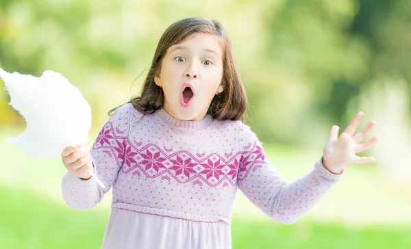 Здивована маленька дівчинка з бавовняними цукерками . — стокове фото