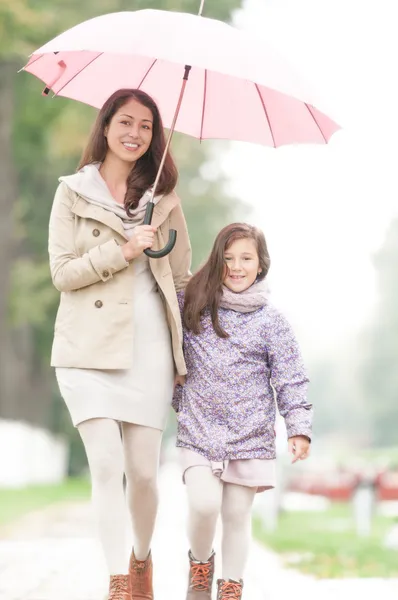 Gelukkig moeder en dochter wandelen in het park. — Stockfoto