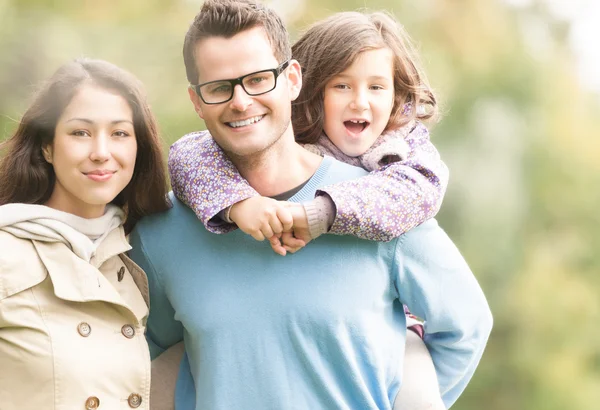 Glückliche dreiköpfige Familie, die Spaß im Freien hat. — Stockfoto