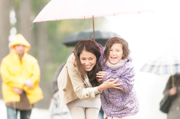 Mère et enfant sous parapluie par temps pluvieux . — Photo