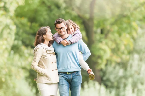 Glückliche dreiköpfige Familie, die Spaß im Freien hat. lizenzfreie Stockbilder