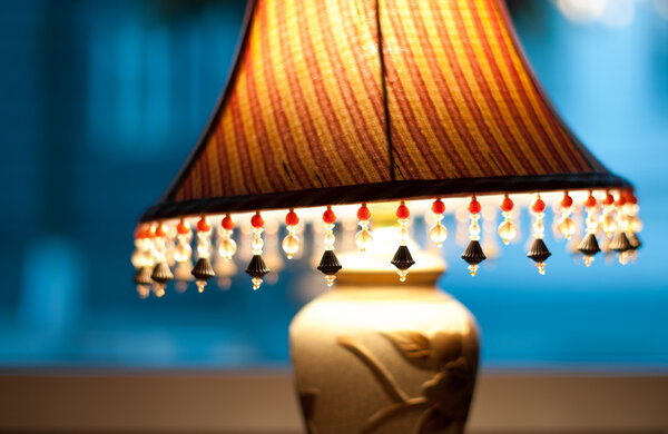 Классическая лампа с тусклым светом возле окна
.