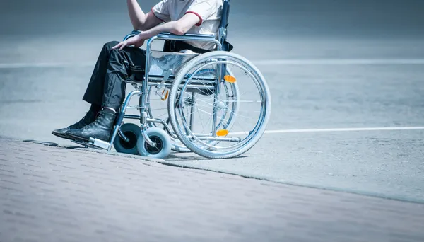 Jonge man in de rolstoel op de weg alleen. — Stockfoto