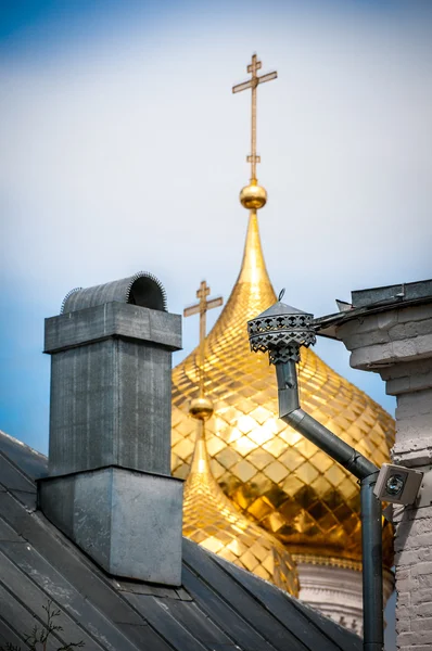 Goldene Kuppeln mit Kreuzen hinter altem Dach. — Stockfoto