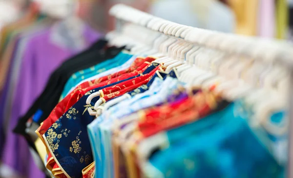 Rijen van kleurrijke kleding op hangers bij shop. — Stockfoto