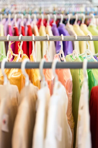 Linhas de roupas coloridas em cabides na loja . — Fotografia de Stock