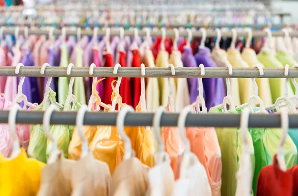 Linhas de roupas coloridas em cabides na loja . — Fotografia de Stock