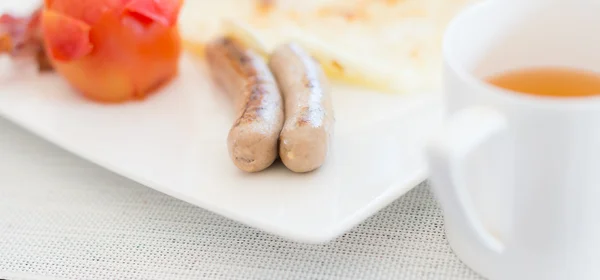 Petit déjeuner savoureux avec saucisses et thé . — Photo