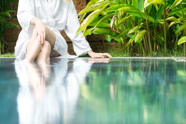 Donna che riposa in piscina con i piedi in acqua . — Foto Stock